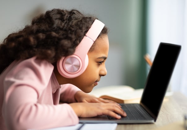 Child suffering from nearsightedness squinting at her computer
