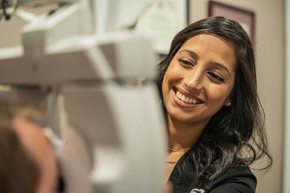 Dr. Chandrani smiling during an eye exam with a patient