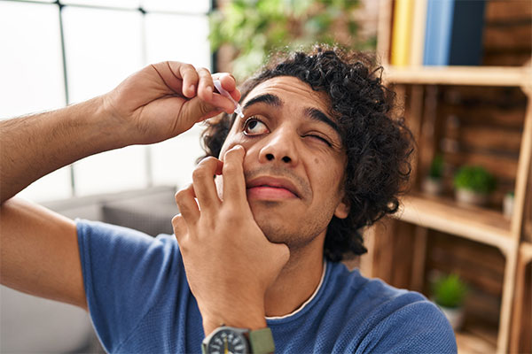 Man putting in eye drops for dry eye relief