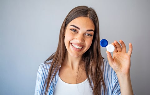Woman smiling while holding contact lenses case